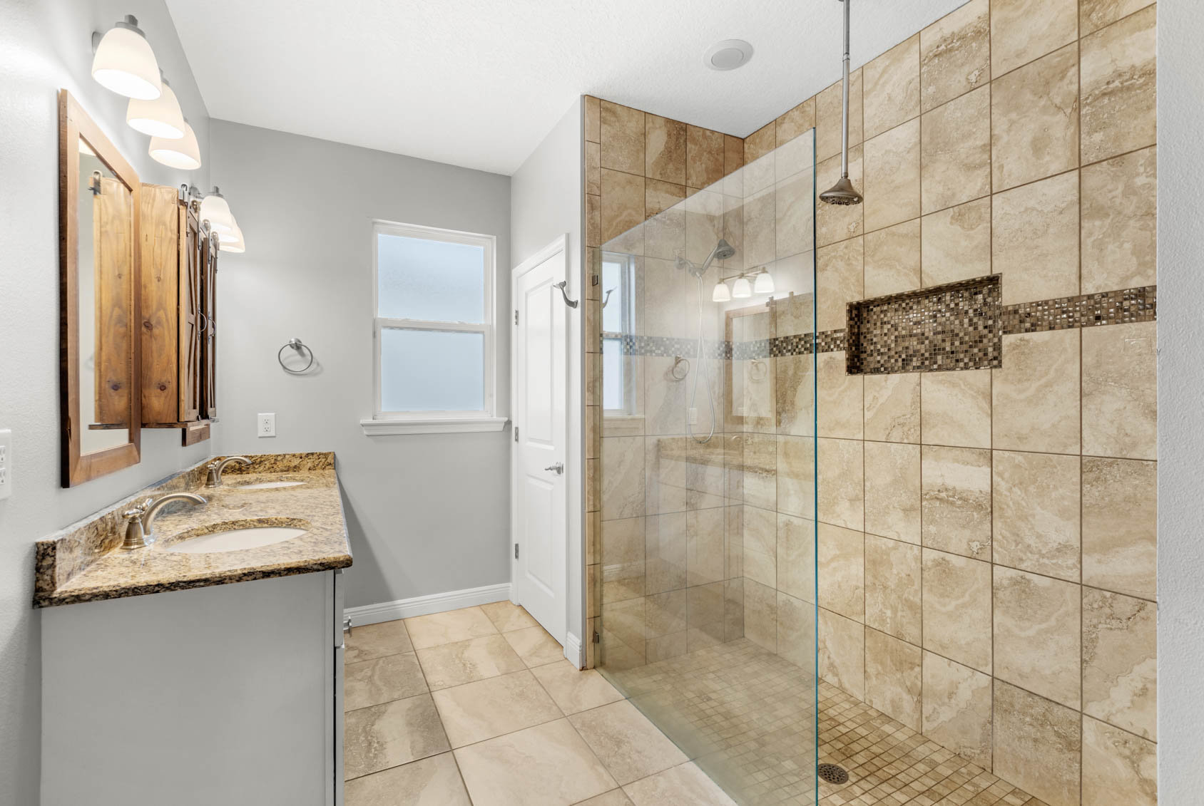 primary bathroom with brown tile and walk in shower